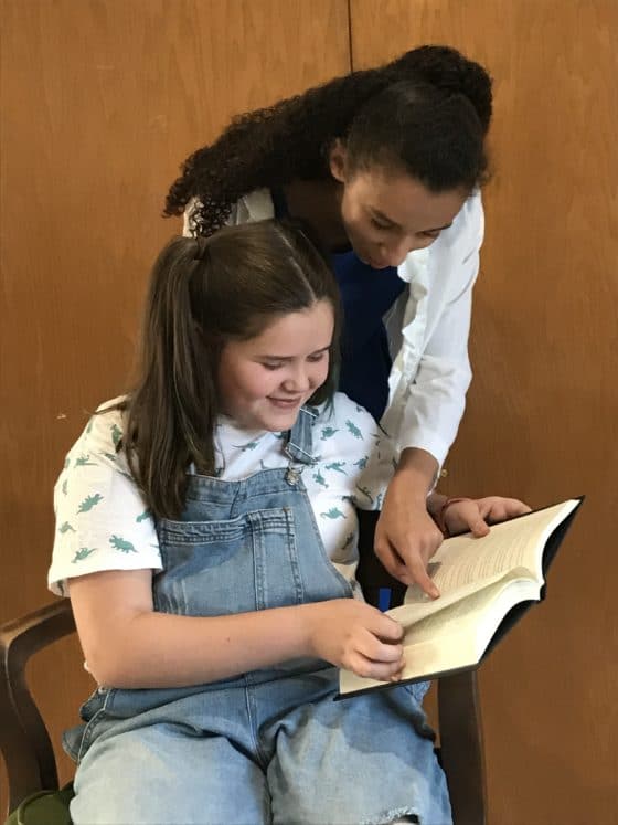 Miss Honey (Kenzie Losinski) helps Matilda (Ella Taylor) with her newest novel.